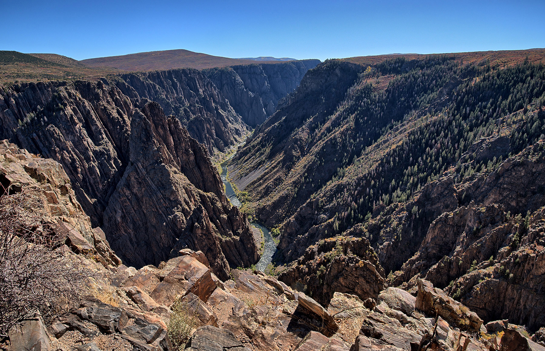 The Gunnison River runs through Black Canyon of the Gunnison at Pulpit Rock.  The river cut through 1,800 Ma gneiss that was formed from an island arc south of Wyoming Province that would become part of North America.  Regional uplift in mid-Tertiary time (30-50 Ma) increased the gradient of the river and strengthened river flow with boulders and gravel and ice from Pleistocene Age glacial melt off to accelerated canyon cutting.