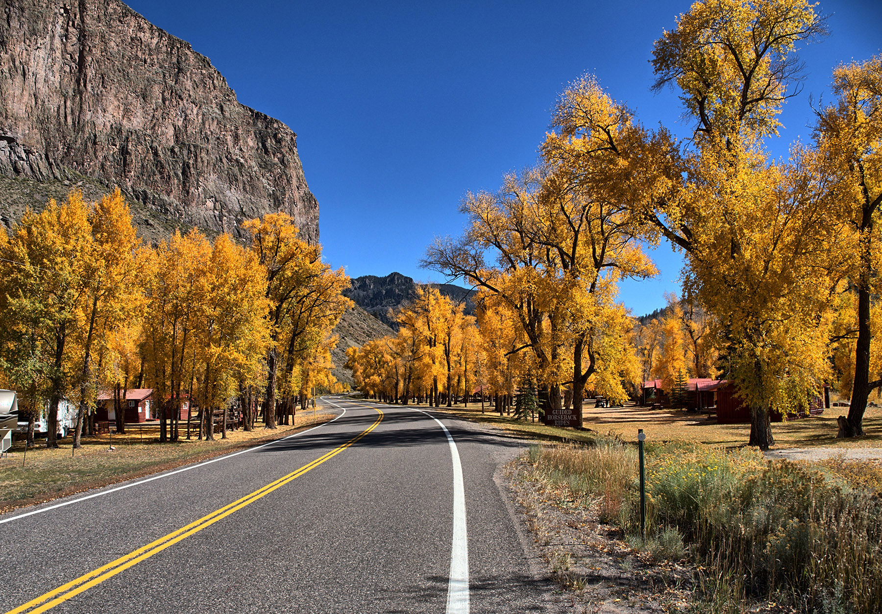 Hwy 149 passes through a cottonwood grove with the Creede Caldera rim on the left.