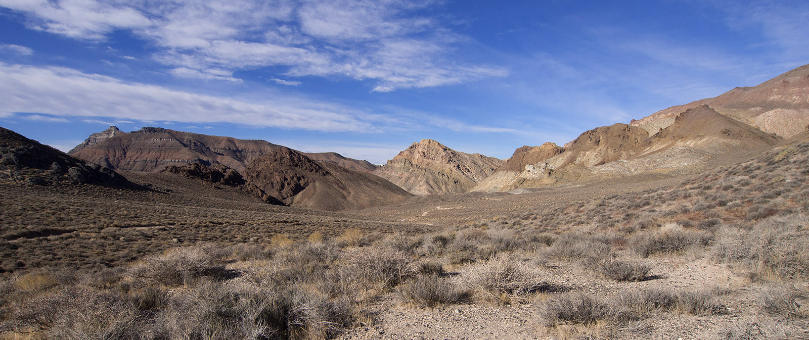 Titus Canyon Road access looking West.  Multiple sedimentary and igneous strata are shown as in a similar photo in Miller and Wright, 2015 (photo 41, reference 4).  Details of strata and formations are shown and described in the following photographs.