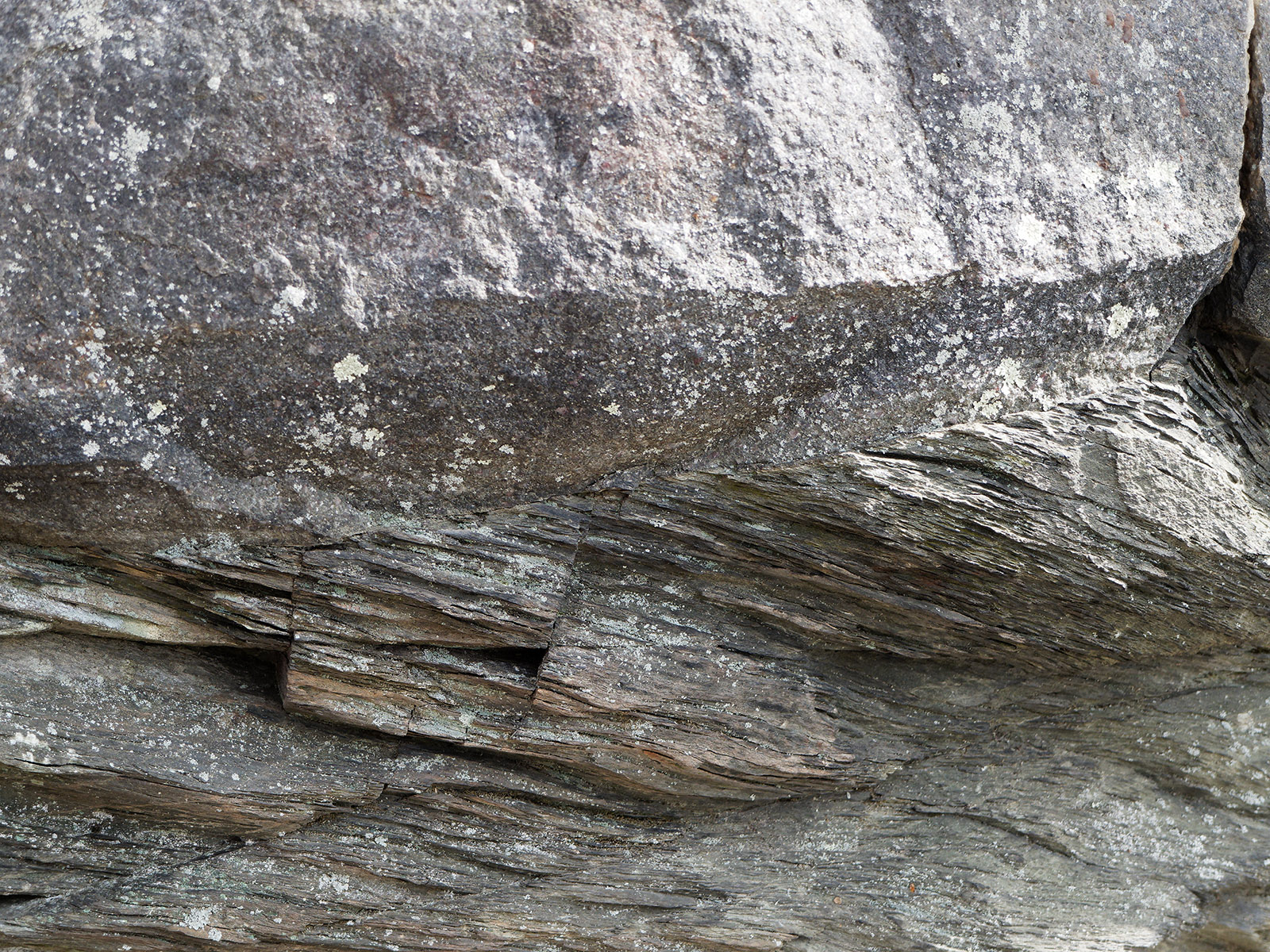 Junction between quartzite (upper) and phyllite (lower).  The greater striation and orientation is due to metamorphic alignment of sediments with high mica content.
