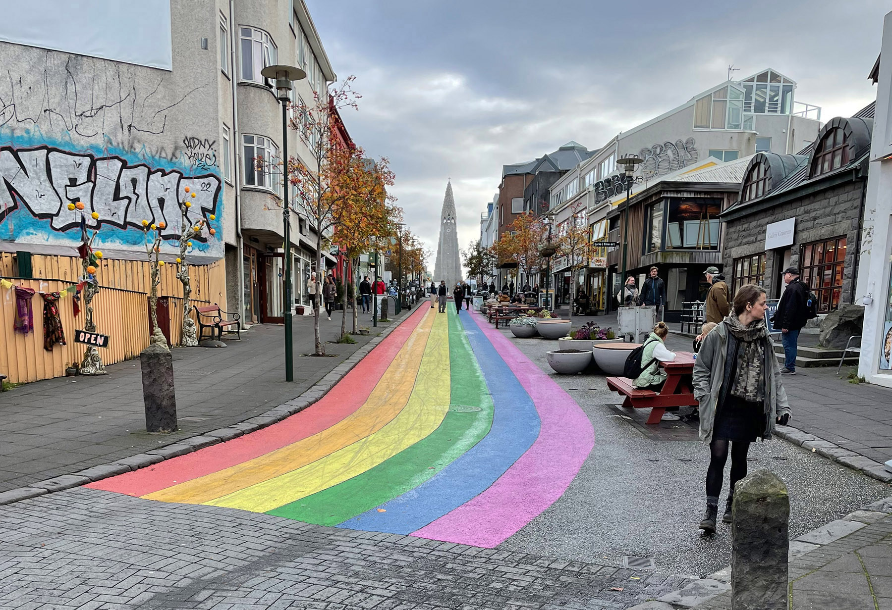 Skólavörðustígur is one of the main streets for shopping, dining and hanging out on the sidewalk, drinking tea/coffee/beer and watching the world go by.   The rainbow flag painted on the most famous street in Reykjavik provides a contrast to Florida’s “Don’t say gay” law.  Photo by Joan Castleman.
