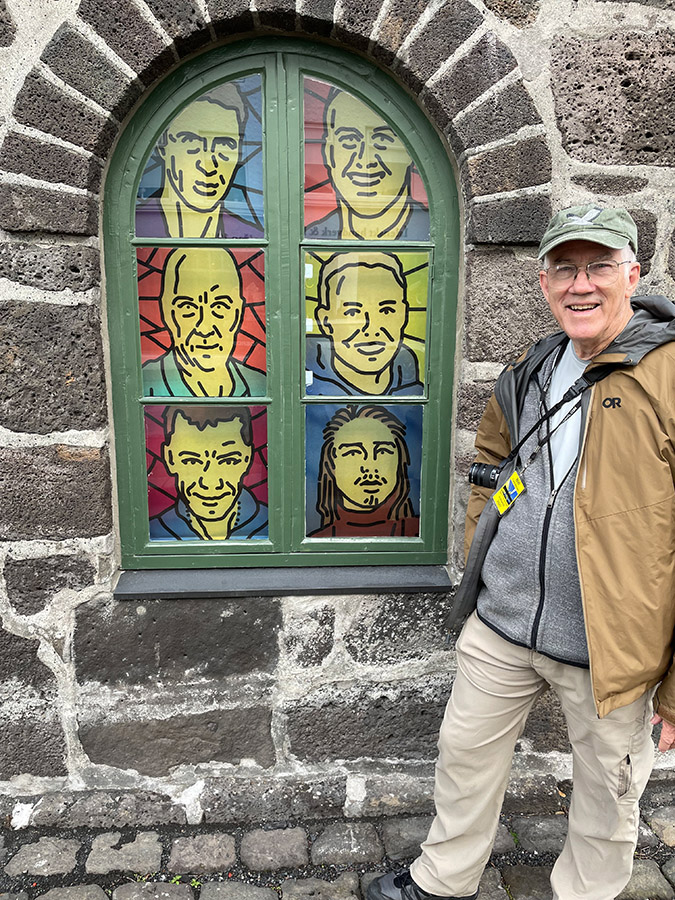 Outside of old city jail on Skólavörðustígur. Windows are painted with portraits of former inmates.  We all be happy! Photo by Joan Castleman.