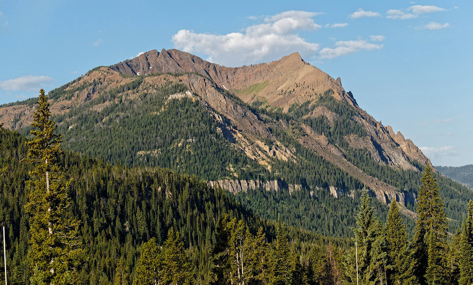 Republic Mountain above Cooke City, Montana with partially eroded Absaroka volcanic rock and conglomerate above Pilgrim limestone.  Gold was discovered in Cooke City in 1870 while the area was still part of the Crow reservation.  After relocating Crow to exploit mineral deposits of gold, silver, copper and lead, extensive mining occurred between the late 1800's and 1930.