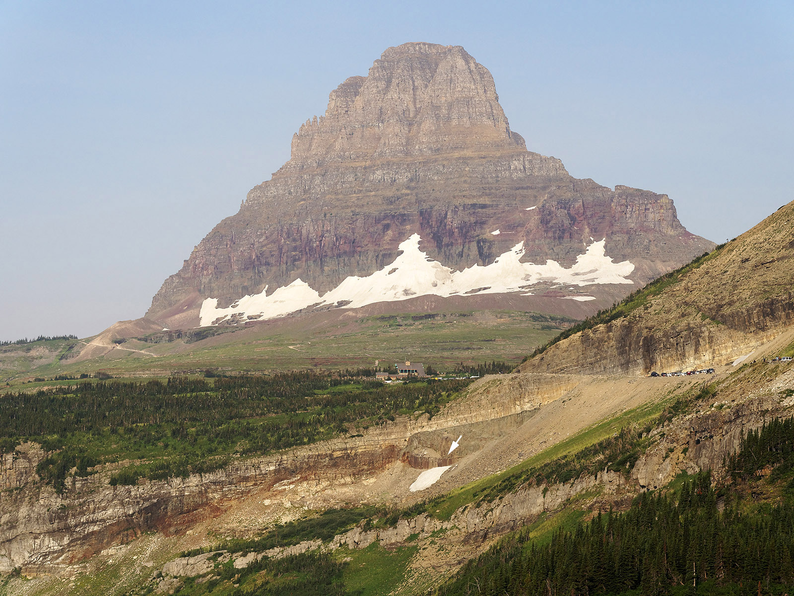 Clements Mountain at the top of Logan Pass is composed of upper Shepard formation and darker lower Snowslip formation.  An igneous sill (diabase at arrow) intrudes into the Helena formation.