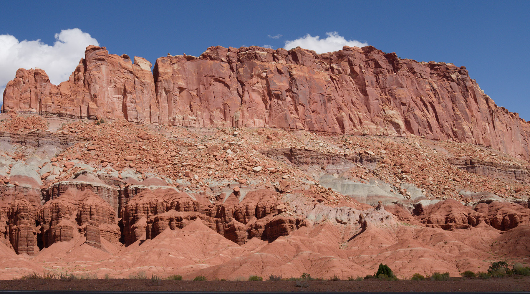 The Fluted Wall, Capitol Reef National Park. Moenkopi rocks formations were deposited in tidal flats during the Triassic Period.
    Deepest:  reddish conglomerate of sandstone and siltstone; 50-100 ft
    Sinbad limestone:  sand silt 70-140ft of yellowish Sinbad limestone
    Torrey member: 250 to 320 foot reddish brown to chocolate siltstone and sandstone
   Moody canyon member:  redishbrown to reddish-orange siltstone:  320 to 430 feet