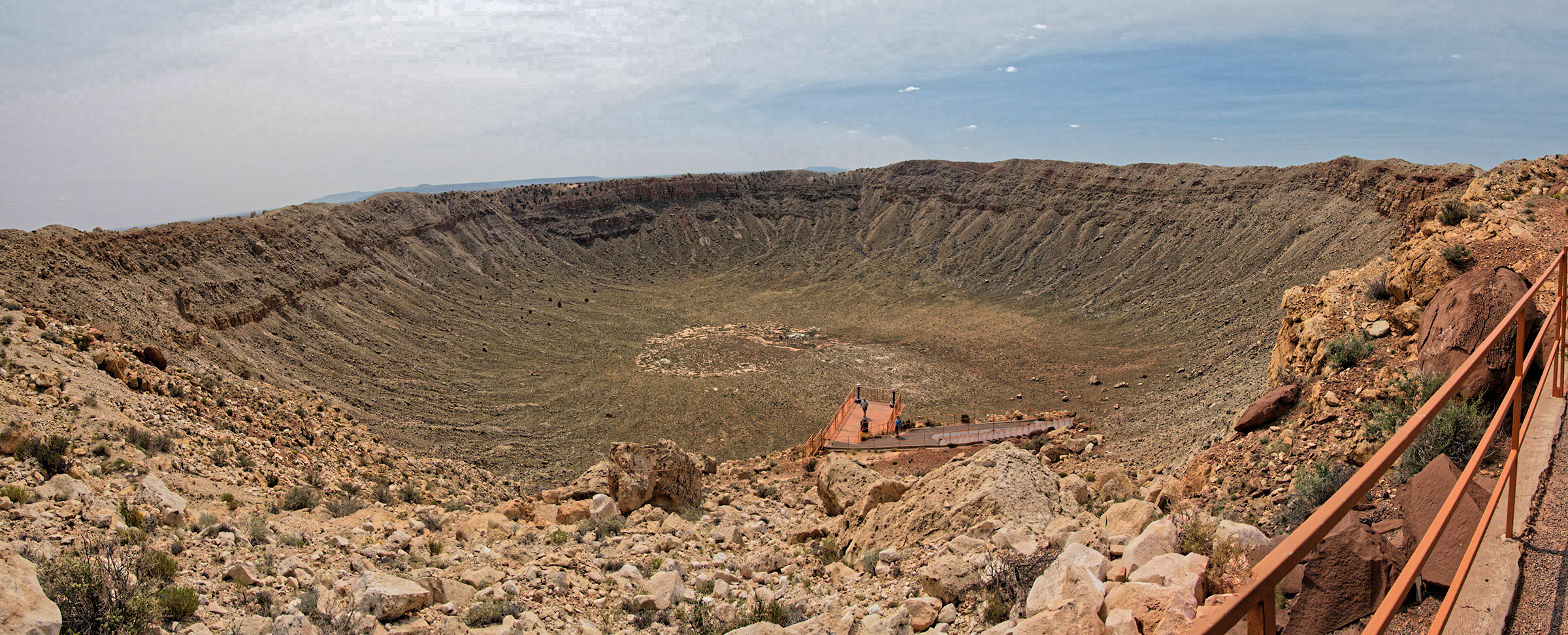 Barringer Meteor Crater near Winslow AZ.  An iron-nickel meteorite estimated to be about 150 feet across struck this location about 50,000 years ago to create this large impact crater within sandstone and limestone now measuring 700 feet deep and 4,000 feet diameter.